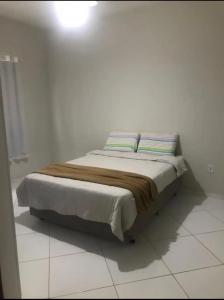 聖馬特烏斯的住宿－Casa de praia em Guriri，白色客房的一张床位,上面有两个枕头