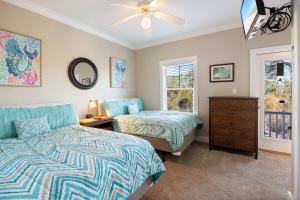 a bedroom with two beds and a dresser and a window at Beachcomber Bliss 38C By Pkrm in Pensacola +32 photos