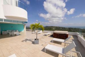 a patio with white benches and a palm tree on a building at Lujoso apartamento Panama in ArraijÃ¡n