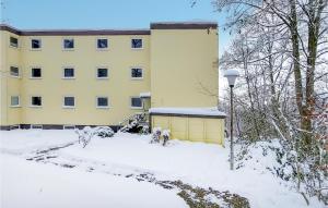 um edifício amarelo com neve em frente em Nice Apartment In St, Andreasberg With Kitchen em Sankt Andreasberg