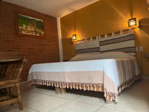 ein Schlafzimmer mit einem Bett in einer Ziegelwand in der Unterkunft Posada Verona in Huasca de Ocampo