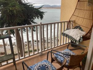 a porch with chairs and a hammock and the ocean at DEPARTAMENTO ESPLÉNDIDA Y PANORÁMICA VISTA FRENTE AL OCÈANO in Puchuncaví