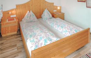 ein Schlafzimmer mit einem großen Holzbett mit zwei Kissen in der Unterkunft Amazing Apartment In Aschau With 2 Bedrooms And Internet in Aschau