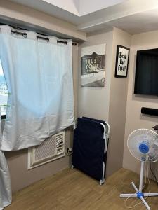 Camera con finestra, tenda bianca e ventilatore. di Fernando's Studio Pad At Monte Carlo With Broadband & Netflix! a Manila