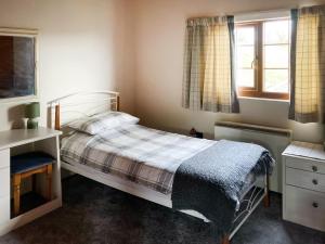 - une chambre avec un lit, un bureau et des fenêtres dans l'établissement Crown Hill Lodge, à Cononley