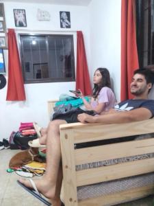 a man and a woman sitting on a bed at departamentos sosa in Mina Clavero