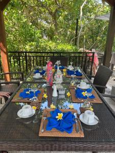 a long table with blue napkins and blue napkins at Kebun Rohani Cottages in Senggigi 