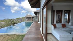 a living room with a couch and a swimming pool at Vivo Villas - Villa Vivo in Uluwatu
