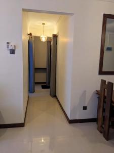 a hallway with a room with two doors and a mirror at Richmond Hill SHA Residencies in Galle