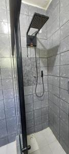 a shower with a shower head in a bathroom at Quarto casal sossegado perto Pelourinho in Salvador