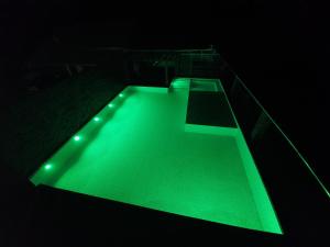 una piscina con luz verde en la oscuridad en Tia zani, en Pomerode