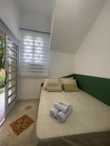 a bedroom with a large bed with two towels on it at Casa Teresa in Rio de Janeiro
