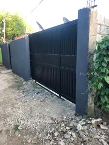 una cerca con una puerta negra en un patio en 1 habitation, en Boca Chica
