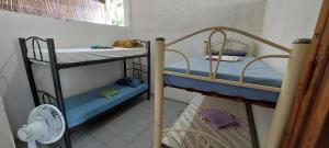 two bunk beds in a room with a fan at Quarto bem próximo ao Pelourinho in Salvador