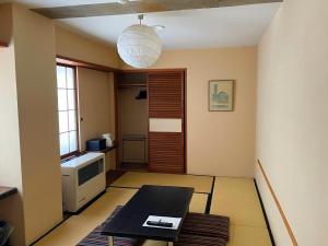 a small living room with a table and a window at the Kinta Naeba in Yuzawa