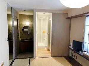 a bathroom with a sink and a toilet and a mirror at the Kinta Naeba in Yuzawa