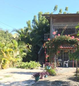 uma casa com flores e plantas em frente em Ixtapa Playa Linda Hostel em Barrio Nuevo