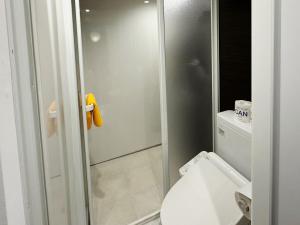 a bathroom with a toilet and a glass shower at the Kinta Naeba in Yuzawa
