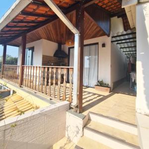 Hospedagem Doce Lar - Casa Bougainville في تيريسوبوليس: شرفة منزل مع سقف خشبي