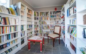 a library with white shelves filled with books at Lovely Apartment In Costa With Outdoor Swimming Pool in Costa