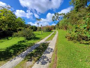 a dirt road in a grassy field with a blue sky at Hotel Claro de Luna in Monteverde Costa Rica