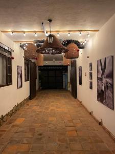 korytarz z dużymi drzwiami i obrazami na ścianach w obiekcie Pancha Mama Hotel Boutique w mieście Villa de Leyva
