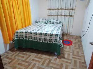 a bedroom with a bed with a green and white blanket at Apartamentos HJJ in Puerto Limón