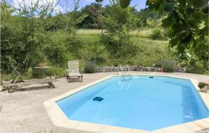 una gran piscina azul en un patio con un banco en Stunning Home In Saint Sernin With Kitchen, en Saint-Sernin
