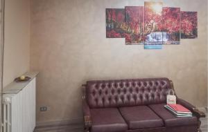 a brown leather couch in a living room with paintings at Lovely Apartment In Luco Dei Marsi With Kitchen in Luco neʼ Marsi