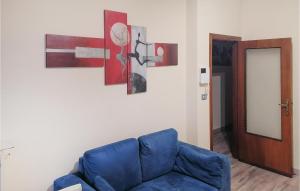 a living room with a blue couch and paintings on the wall at Lovely Apartment In Luco Dei Marsi With Kitchen in Luco neʼ Marsi