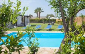 - une piscine dans une cour avec des chaises et un arbre dans l'établissement Nice Home In Scicli With Swimming Pool, à Scicli