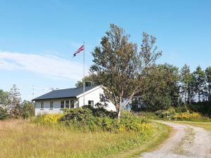 una casa blanca con una bandera americana encima en Holiday home Nordfold en Nordfold