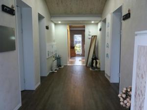 an empty room with a hallway with a door and wood floors at Bookmark Guesthouse in Seogwipo