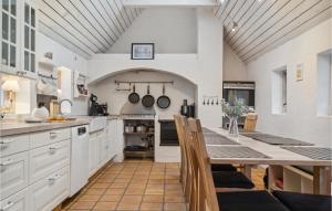 cocina con armarios blancos y mesa de madera en Amazing Home In Kirke Sby With Kitchen en Kirke Såby