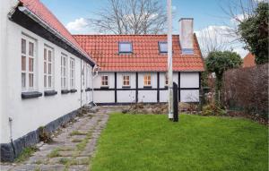 une maison blanche avec un toit rouge et une cour dans l'établissement Amazing Home In Kirke Sby With Kitchen, à Kirke Såby