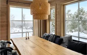 a dining room with a wooden table and windows at Awesome Home In Kvam With Sauna in Kvam