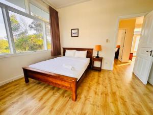 a bedroom with a bed and a large window at Bougainvillea Sealinks City PC16-17-18 in Ấp Phú Tịnh (2) +21 photos