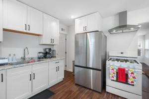 een keuken met witte kasten en een roestvrijstalen koelkast bij Foothill getaway in Los Angeles