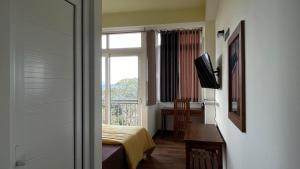 a room with a window and a bed and a television at Sun Dove Suite in Kandy