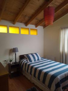 Mini Casa en Viña del Mar في فينيا ديل مار: غرفة نوم بسرير وبطانية مخططة باللون الأزرق والأبيض