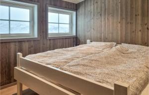 uma cama grande num quarto com duas janelas em Gorgeous Home In seral With Kitchen em Åseral