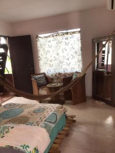 a bedroom with a hammock in a room with a window at Mar y Luna in Mérida