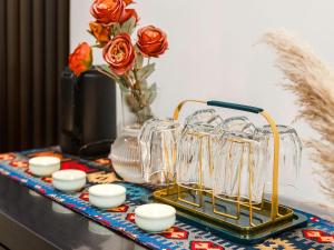 una mesa cubierta con vasos y un jarrón con rosas en Annie 公寓-2602, en Kunming
