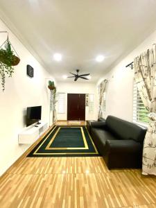 sala de estar con sofá y ventilador de techo en Umbai Village Melaka homestay, en Merlimau