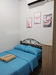 a bedroom with two beds with blue sheets and pictures on the wall at G&M Comfy place for your stay at SMDC Coast Residences in Manila