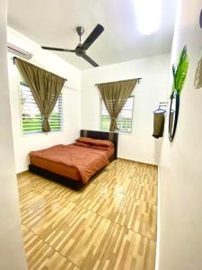 1 dormitorio con 1 cama y ventilador de techo en Umbai Village Melaka homestay, en Merlimau