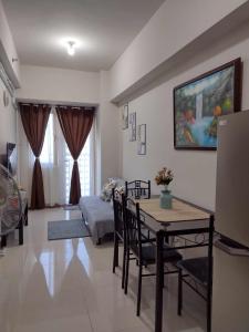 a living room with a table and a bedroom at G&M Comfy place for your stay at SMDC Coast Residences in Manila