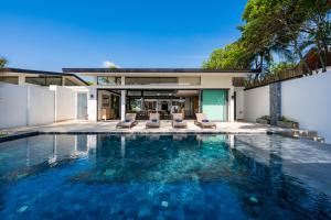 a swimming pool in the backyard of a house at Twin Villas Natai South - 5 Bedroom Luxury Beach Front Villa in Natai Beach
