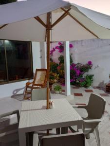 a table and chairs with an umbrella on a patio at Hospedaje Casa Pachi en Cartagena de Indias in Cartagena de Indias