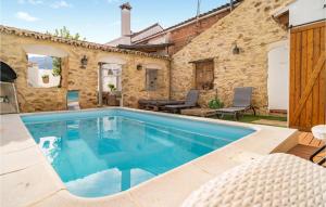 una piscina frente a una casa de piedra en Cozy Home In El Colmenar With Outdoor Swimming Pool, en El Colmenar